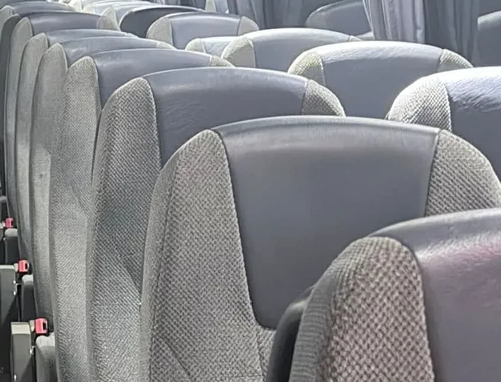 Primer plano de las butacas reclinables grises de cabecero azul del autocar VDL de 55 plazas de Winking Bus